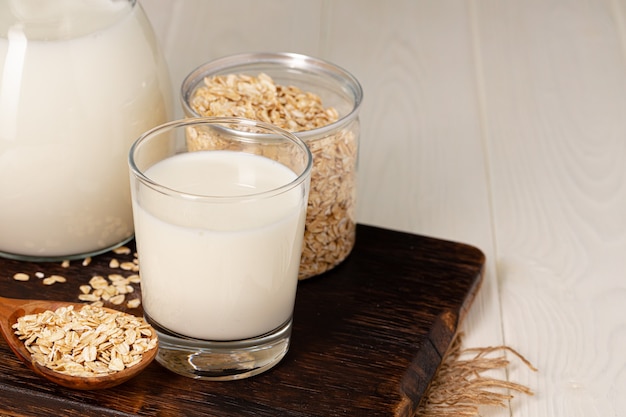 Glas melk en havervlokken op houten tafel close-up