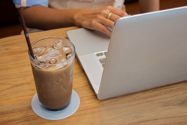 Glas melk koffie drinken op houten tafel