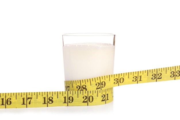 Glas melk met meetlint geïsoleerd op wit