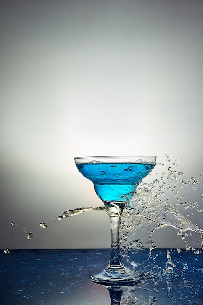 Glas met blauwe champagne of cocktail. Levitatie