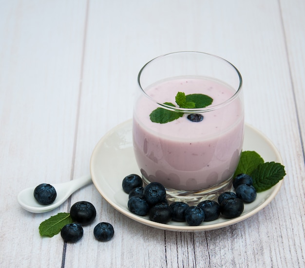 Glas met bosbessenyoghurt op een tafel