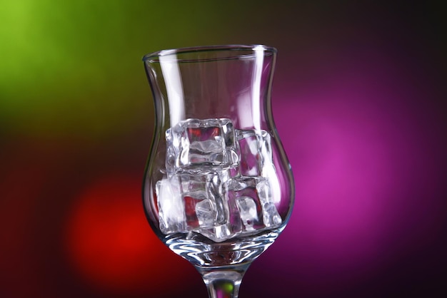 Glas met ijsblokjes op gekleurde achtergrond
