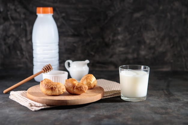 Glas met melk en croissants met honing op een zwarte achtergrond. Lekker Frans ontbijt. Nagerecht. Ruimte voor tekst