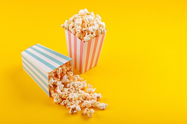 Glas met popcorn op een gele achtergrond