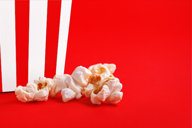 Glas met popcorn op een rode achtergrond