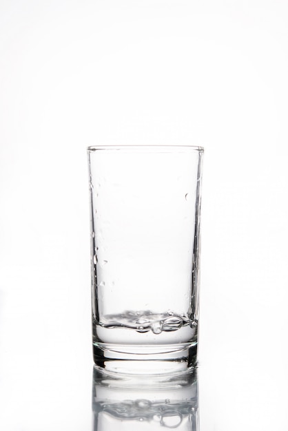 Glas met water op wit wordt geïsoleerd dat