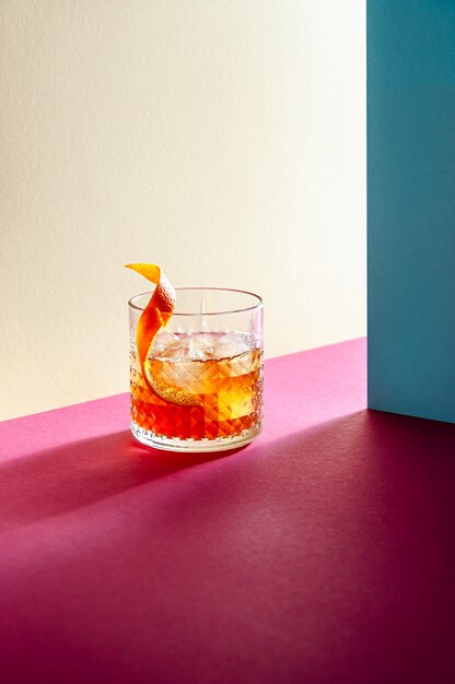 Glas met whisky en ijsblokje op tafel met harde schaduwen. Moderne isometrische stijl. Creatief concept