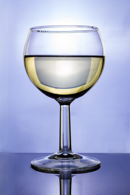 Foto glas met witte wijn op blauw