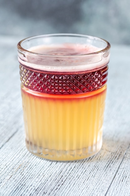 Glas New York Sour gegarneerd met cocktailkers en citroenschil