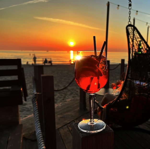 glas oranje water op de tafel van het strandrestaurant bij zonsondergang vakantie vrije tijd