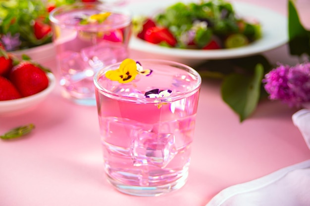 Glas roze violet paars cocktail versierde bloemen altviool viooltje