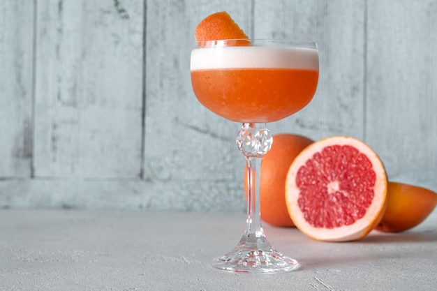 Glas ruby cocktail gegarneerd met grapefruitschil
