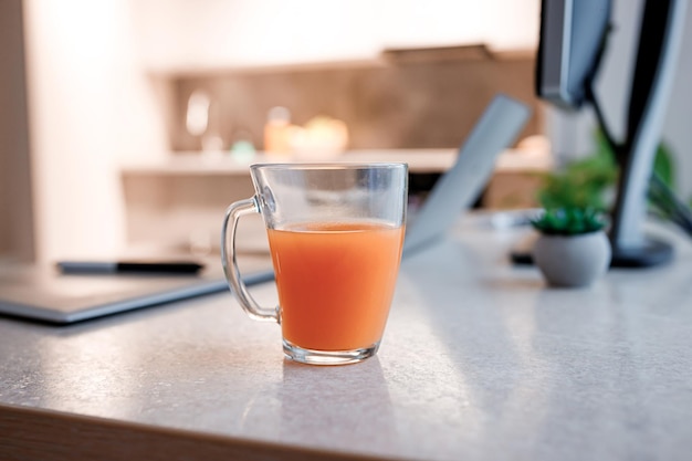 Glas smakelijke jus d'orange staande op de keukentafel