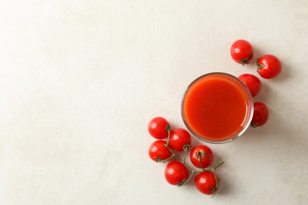 Glas tomatensap en tomaten op geweven wit