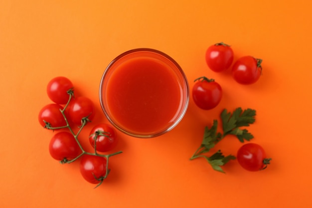 Glas tomatensap en tomaten op sinaasappel