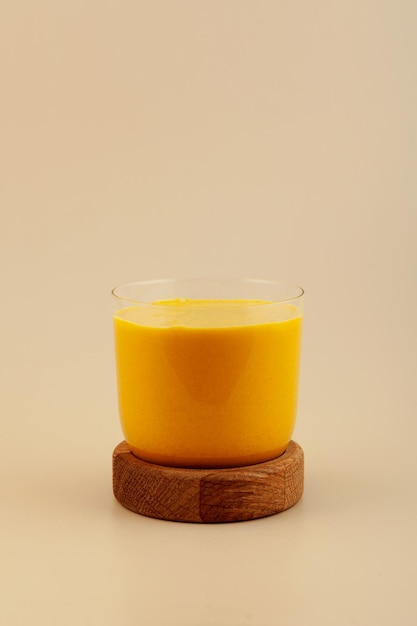 Foto glas turmeric latte indian golden milk beverage met kurkuma poedermelk en honing