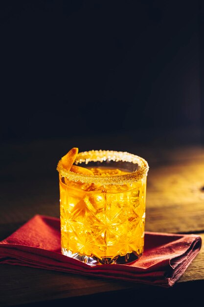 Glas van de cocktail negroni op een oud houten bord Drink met gin campari martini rosso en sinaasappel een Italiaanse cocktail een aperitief voor het eerst gemengd in Firenze Italië in 1919 alcoholische bittere cocktail