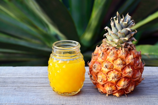 Glas vers ananassap en rijp ananasfruit op rustieke houten lijst Vers geperst ananassap Gezond voedsel, dieet of veganistisch voedselconcept.