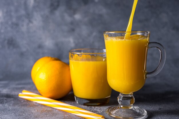 Glas vers sinaasappelsap, rijp oranje fruit en plakjes