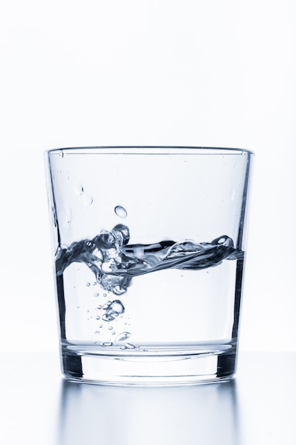 Glas water dat op wit wordt geïsoleerd