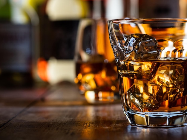 Glas whisky on the rocks op een houten barblad