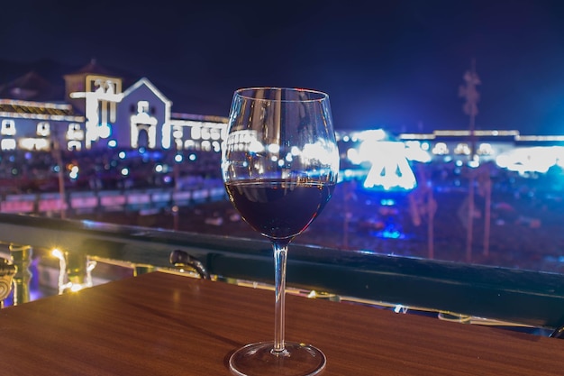 Glas wijn met het centrale plein van villa de leyva met kerstverlichting op de achtergrond