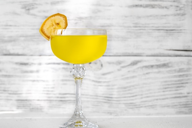 Foto glas yellow submarine cocktail gegarneerd met plakje banaan