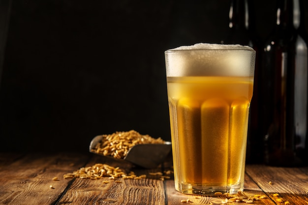 Glas zelfgemaakte bier op een houten tafel. glas ambachtelijk bier op een donkere achtergrond.