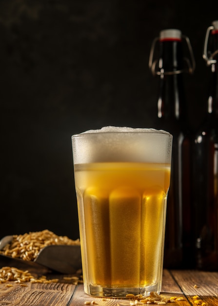 Glas zelfgemaakte bier op een houten tafel. Glas ambachtelijk bier op een donkere achtergrond.