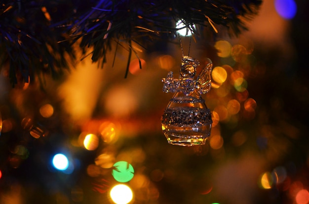 Glaskerstmisengel op een Kerstboom met lichten