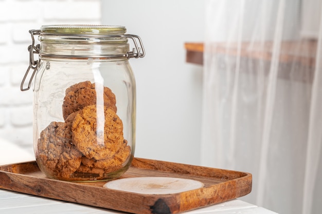 Glaskruik haverkoekjes op houten dienblad in keuken