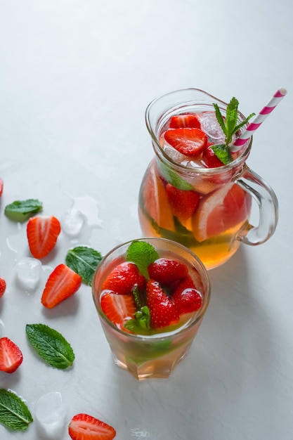 Glasmix cocktail aardbei limoen grapefruit op tafel stukjes aardbeien muntijs