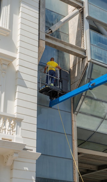 Glasreiniger in het winkelcentrum met behulp van het mobiele platform