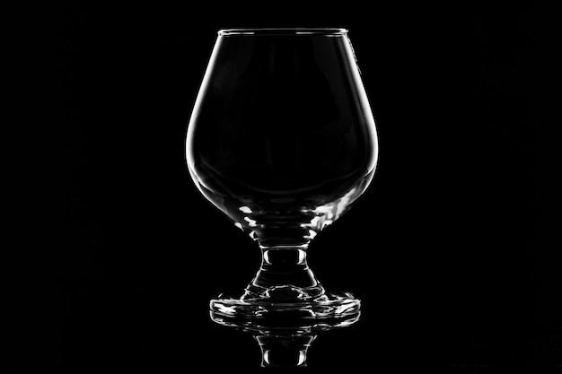 Photo a glass of alcohol with a black background and the bottom of it.