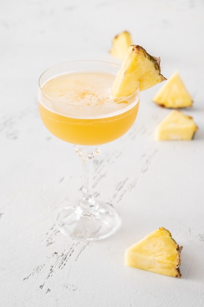 Glass of Algonquin cocktail garnished with pineapple slice