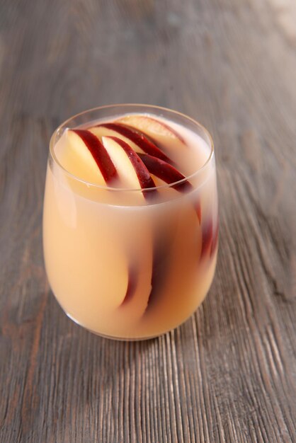 Glass of apple cider on wooden background