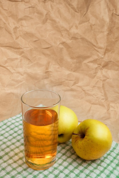 A glass of apple juice with apples