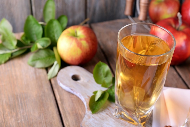 Glass of apple juice on wooden background