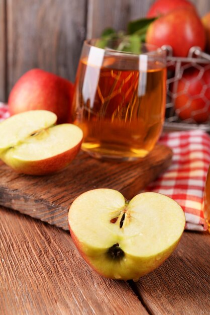 Glass of apple juice on wooden background