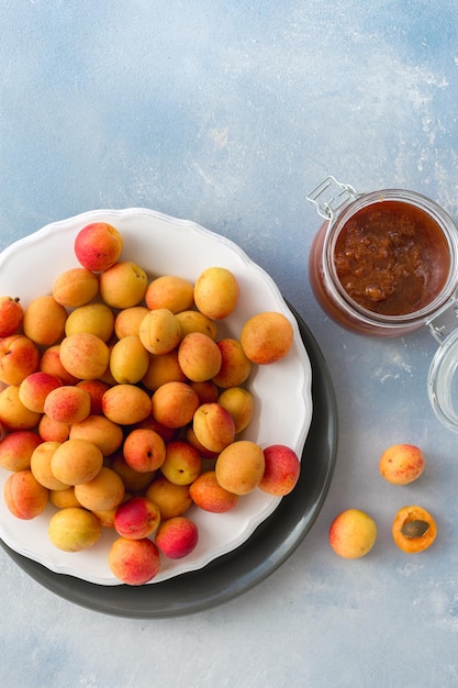 Foto bicchiere di marmellata di albicocche e albicocche appena colte