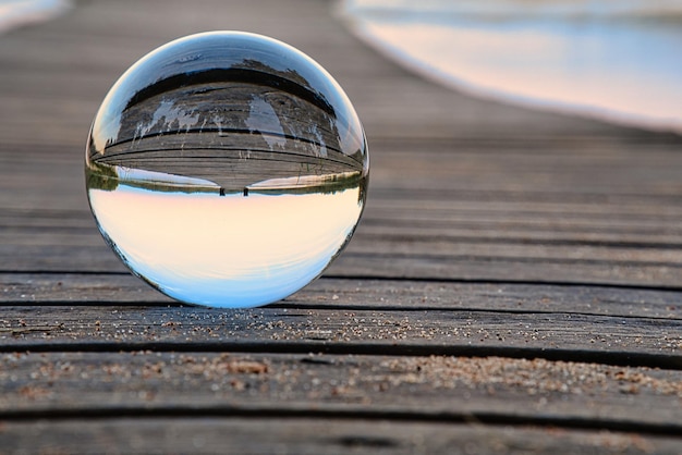 Glass ball on a wooden pier at a Swedish lake at evening hour Nature Scandinavia