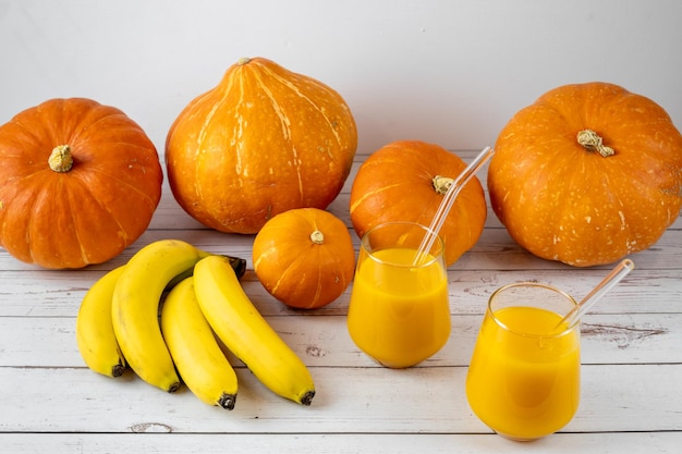 A glass of banana and pumpkin smoothie on a wooden table