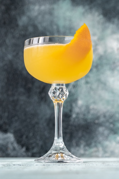 Glass of Bee's Knees cocktail garnished with orange zest