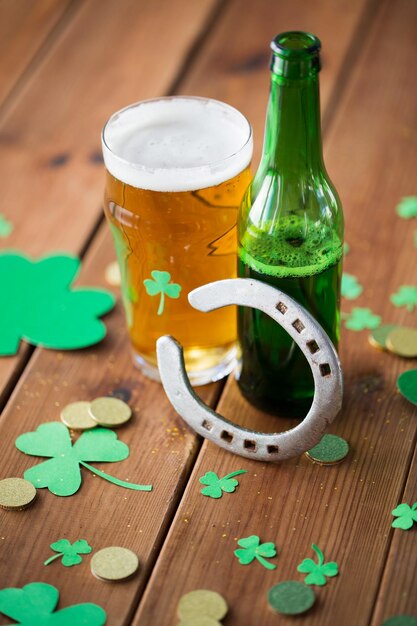 glass of beer bottle horseshoe and gold coins