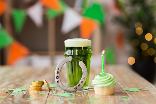 Photo glass of beer cupcake horseshoe and gold coins