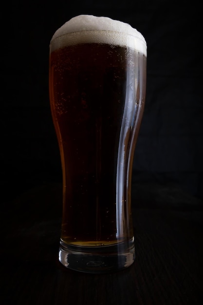 A glass of beer on a dark background