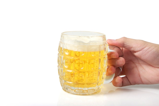 白い表面の背景に分離された手でビールのグラス
