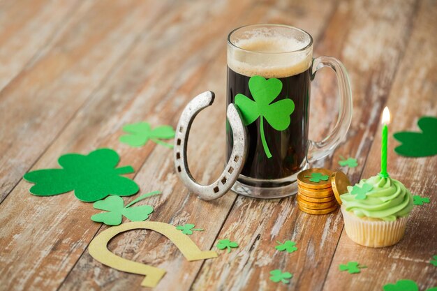 glass of beer horseshoe green cupcake and coins