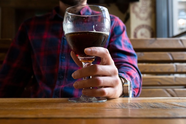 Glass of beer in a mans hand closeup Alcoholism concept Fighting alcohol addiction crisis depression