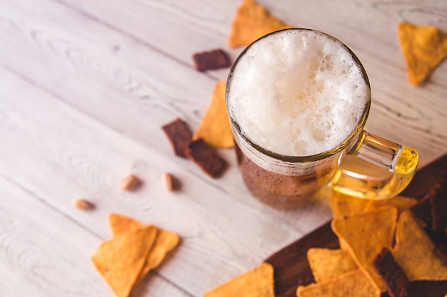 Foto boccale di birra in vetro e snack di birra su legno, vista dall'alto